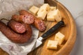 Ring Salami pork sausage with German BierbeiÃÅ¸er and Edamer cheese in wax paper with knife on wooden board background for Brotzeit